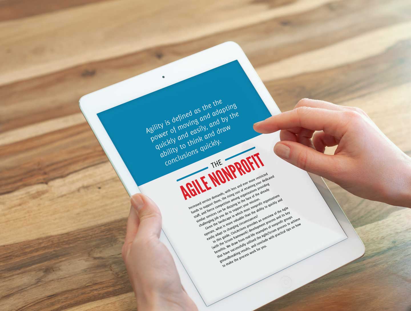 Hands holding a tablet displaying a page from the guide.